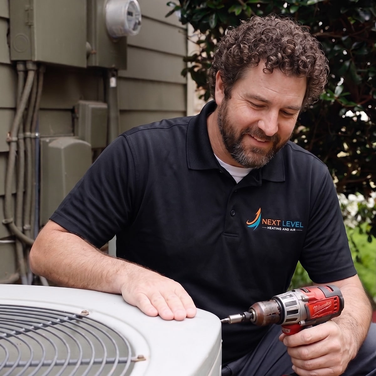 Next Level Heating and Air technician using drill on condenser unit panel