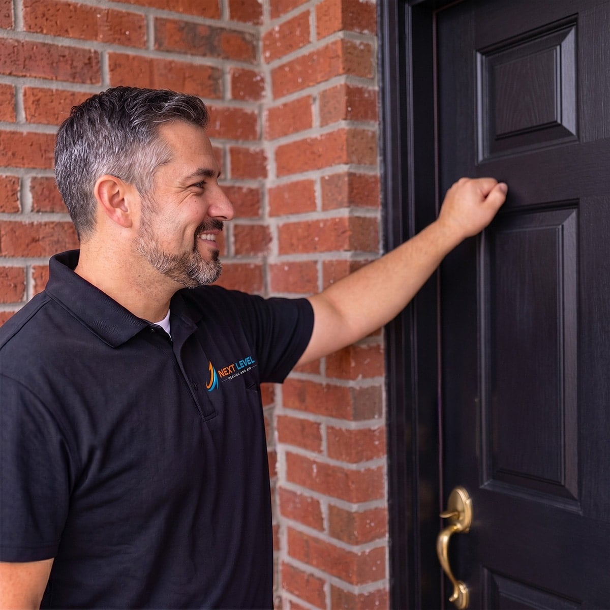 Smiling service technician knocking on customer's front door for appointment